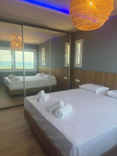 a bedroom with two beds and a large mirror at POSEIDON Seaview Presidential in Paralia Katerinis
