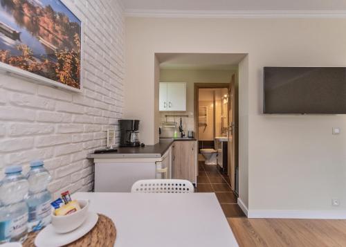 a white kitchen with a table and a counter top at Willa Aleksandra - Apartamenty in Międzybrodzie Żywieckie