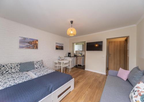 a bedroom with a bed and a couch and a table at Willa Aleksandra - Apartamenty in Międzybrodzie Żywieckie