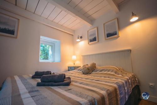 une chambre avec un grand lit avec un animal en peluche dessus dans l'établissement Le Mas de mon père XVIIeme siecle, à Saint-Jean-de-Valériscle