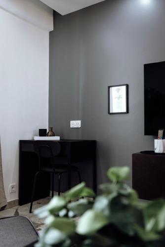 a living room with a desk and a television at Prestige Lumineux Jacuzzi Parking privé in Mulhouse