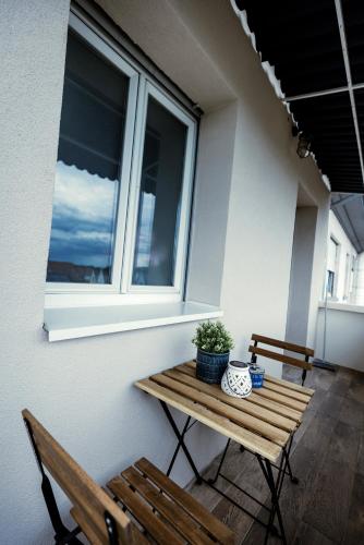 a porch with two benches and a table and a window at Prestige Lumineux Jacuzzi Parking privé in Mulhouse