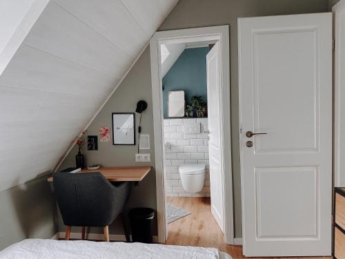 an attic bedroom with a desk and a staircase at Stilvolles Gästezimmer mit Bad in Mechernich-Zentrum in Mechernich
