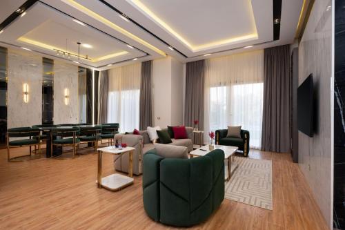 un soggiorno con un divano, sedie e un tavolo di A fully furnished villa with a private pool inside the Hydepark Compound in Fifth Settlement for rent a Il Cairo