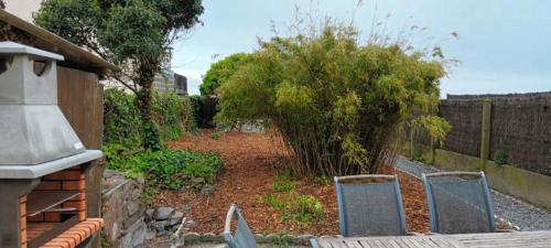 un jardin avec deux chaises devant une clôture dans l'établissement Castel de Cherrueix, à Cherrueix