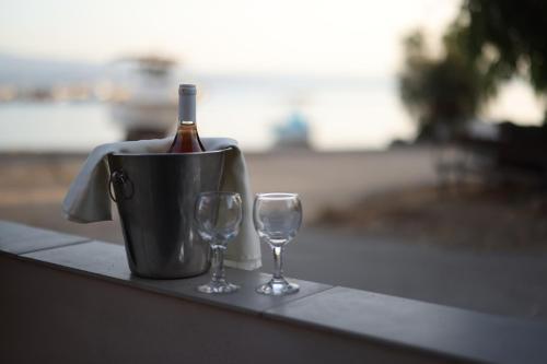 a bottle of wine in a bucket next to two wine glasses at Filippos Apartments in Amarinthos