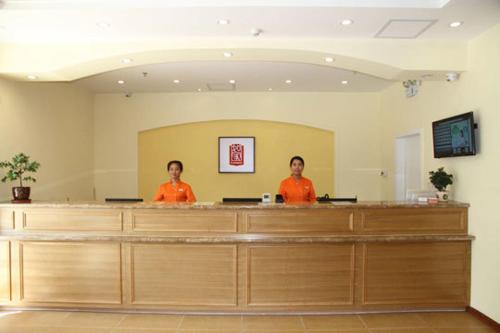 two women standing at a cash counter in a salon at Home Inn Shanghai Nicheng Lingang Facility Industrial Park in Nanhui
