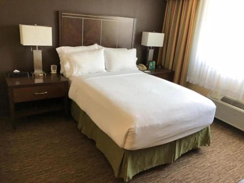 a large bed in a hotel room with two night stands at Holiday Inn Hotel & Suites Anaheim by IHG in Anaheim