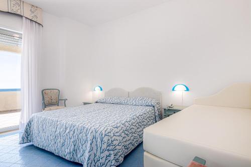 a bedroom with two beds and a window at Hotel Poseidon in Diamante
