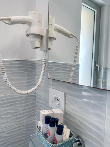 a bathroom with a mirror and a rack with bottles at Hotel Poseidon in Diamante