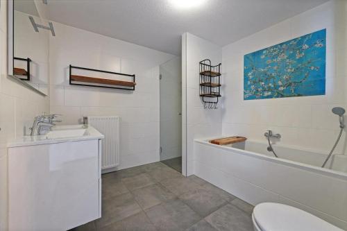 un bagno con vasca, lavandino e WC di Kabbelaarsbank 503 - Port Marina Zélande NOT INTENDED FOR COMPANY OR WORK-RELATED STAYS a Ouddorp
