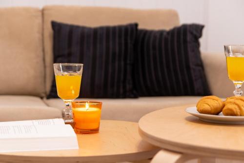 a table with two glasses of orange juice and a plate of food at Eden - A Night near Athens Int Arpt in Spáta