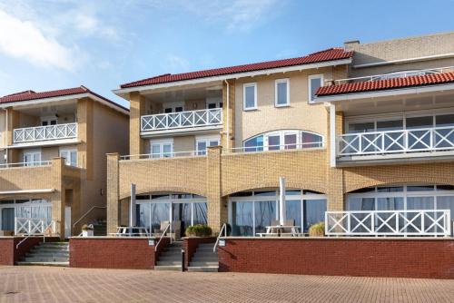 a large brick building with windows and stairs at Kabbelaarsbank 506 - Port Marina Zélande in Ouddorp