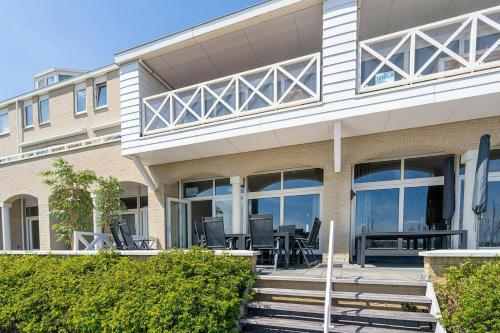 a house with chairs and tables in front of it at Kabbelaarsbank 2C - Port Marina Zélande in Ouddorp