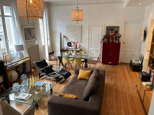 un salon avec un canapé et une table dans l'établissement Bel appartement terrasse, à Bordeaux