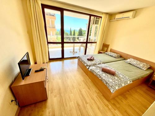 a bedroom with a bed and a large window at Julia Vigo Panorama apartments in Nesebar