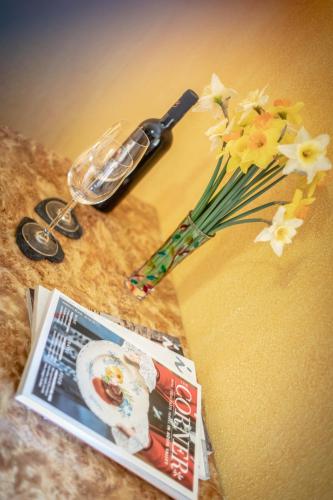 a magazine and a pair of scissors and flowers on a table at Hotel Beau Sejour Pré-Saint-Didier in Pré-Saint-Didier