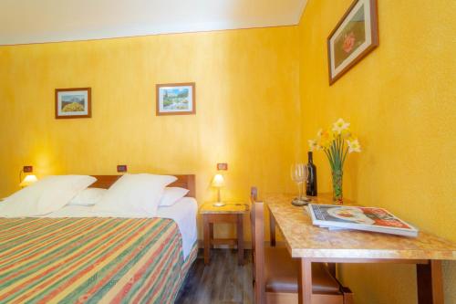 a hotel room with two beds and a desk at Hotel Beau Sejour Pré-Saint-Didier in Pré-Saint-Didier
