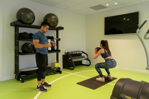 a man and a woman standing in a gym at Holiday Suites Zeebrugge in Zeebrugge