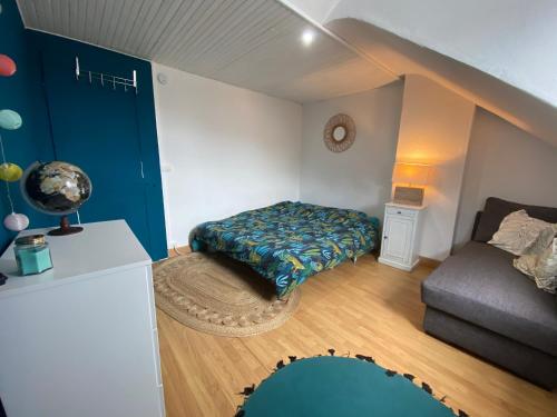 une petite chambre avec un lit et un canapé dans l'établissement La petite cabane d'Onésime, à Fécamp