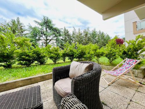 une chaise en osier et une chaise assise sur une terrasse dans l'établissement Lyon authentique, à Lyon