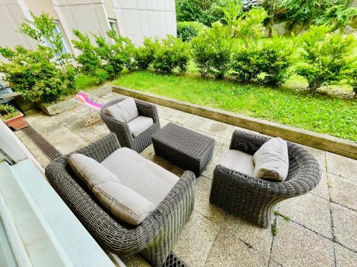 un patio avec des chaises et des chaises en osier et une table dans l'établissement Lyon authentique, à Lyon