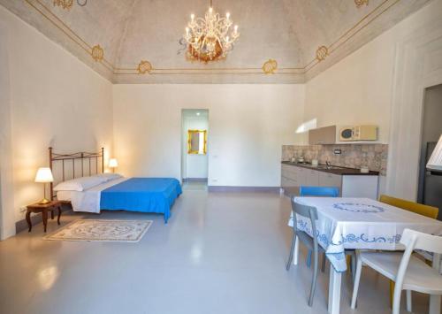 1 dormitorio con 2 camas, cocina y lámpara de araña en Casa Elsa, en Procida