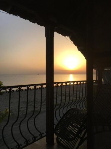 a sunset over the ocean from a balcony at Ανατολή apartment in Néa Meságkala
