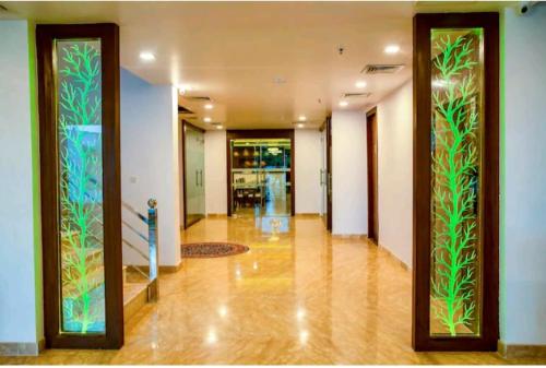 a hallway with doors with plants painted on them at Hotel Agra Grande By Goyal Hoteliers in Agra