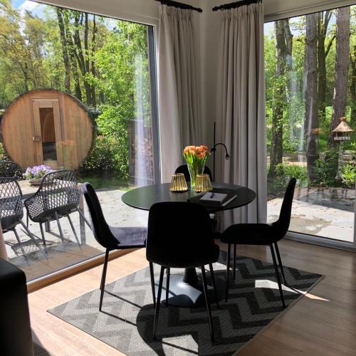 a dining room with a table and chairs and a large window at Vakantiewoning Mystiek in Zutendaal