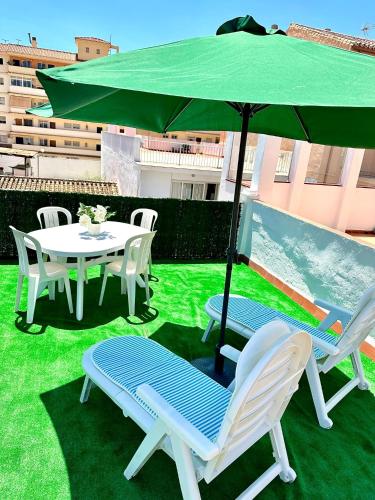a table and chairs under an umbrella on a lawn at Fuengirola Casa Centro Mar y Sol in Fuengirola