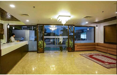 a living room with a person working on a laptop at Hotel Agra Grande By Goyal Hoteliers in Agra