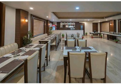 a restaurant with tables and chairs in a room at Hotel Agra Grande By Goyal Hoteliers in Agra