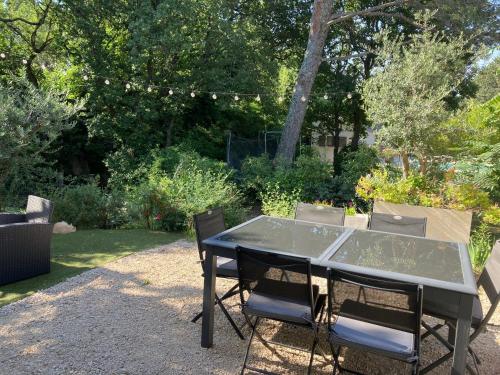 - une table et des chaises noires dans le jardin dans l'établissement Bastide du Safrus, à Villeneuve-lès-Avignon