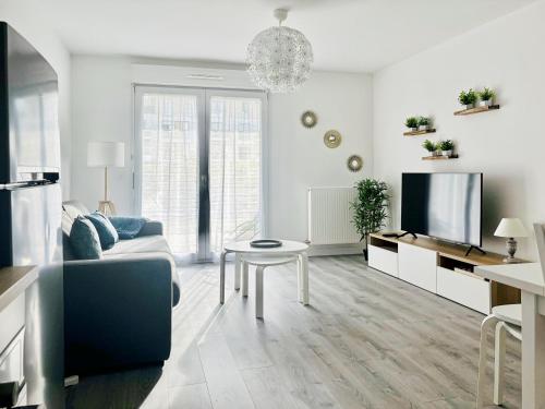 un salon blanc avec un canapé et une télévision dans l'établissement Sunny Suite Disneyland Paris - Rentaway BnB, à Montévrain
