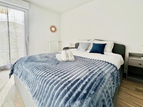 - une chambre avec un lit bleu et blanc et une fenêtre dans l'établissement Sunny Suite Disneyland Paris - Rentaway BnB, à Montévrain