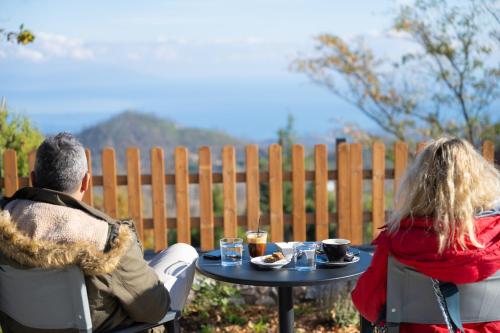 a man and a woman sitting at a table with food at EVIA FOREST VILLAGE in Pappádhes
