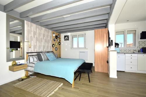 a bedroom with a bed and a kitchen at les 2 dauphins in Le Barcarès