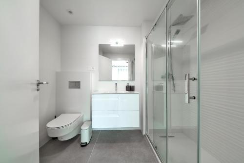 a bathroom with a toilet and a glass shower at Apartamentos Arenal 2 in Jávea