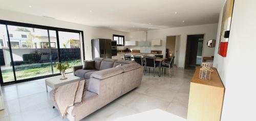 Il comprend un grand salon avec un canapé et une cuisine. dans l'établissement Villa Moderne St Cyprien Village, à Saint-Cyprien