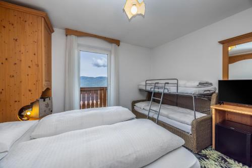 a bedroom with two beds and a window at Hotel Tirol- Natural Idyll in Montesover