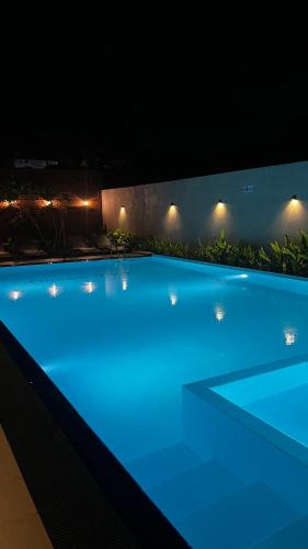 a large swimming pool lit up at night at Ocean View tourist guest house at Negombo beach near the airport in Negombo