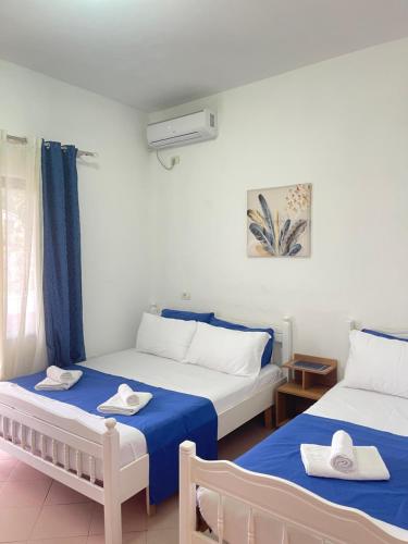 two beds in a room with blue and white at Vogue Rooms in Golem