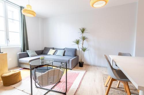 un salon avec un canapé et une table dans l'établissement « AU VINCI VERT » Appartement 4 pers. NEUF, à Amboise