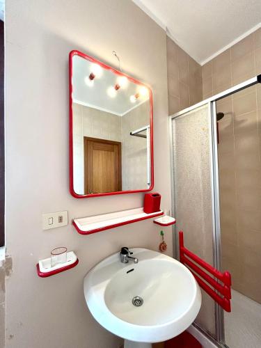 a bathroom with a white sink and a mirror at NURAS - Penthouse Antonietta with view in Alghero