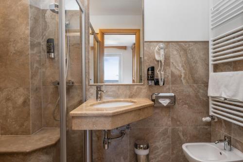 a bathroom with a sink and a shower at Hotel Tirol- Natural Idyll in Montesover
