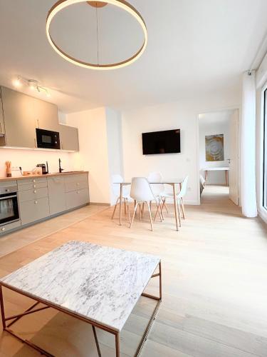 un salon blanc avec une table et des chaises dans l'établissement Nice flat Paris Clichy, à Clichy