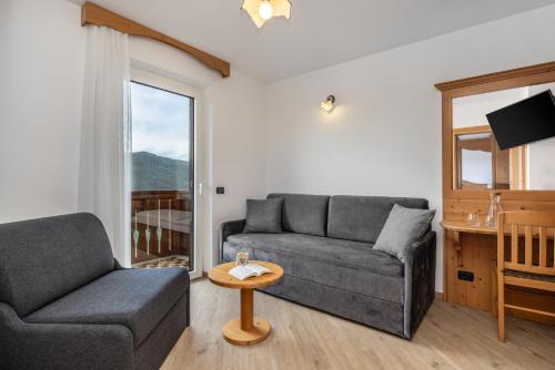 a living room with a couch and a chair at Hotel Tirol- Natural Idyll in Montesover