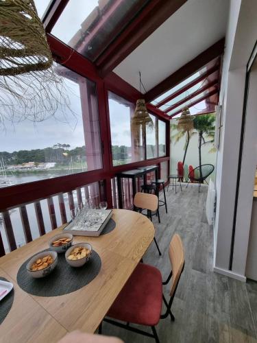une salle à manger avec une table et des chaises en bois dans l'établissement PORT SUD - T3 en duplex avec vue panoramique sur le port de Capbreton, à Capbreton