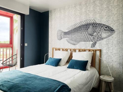 - une chambre avec un lit avec un poisson sur le mur dans l'établissement PORT SUD - T3 en duplex avec vue panoramique sur le port de Capbreton, à Capbreton